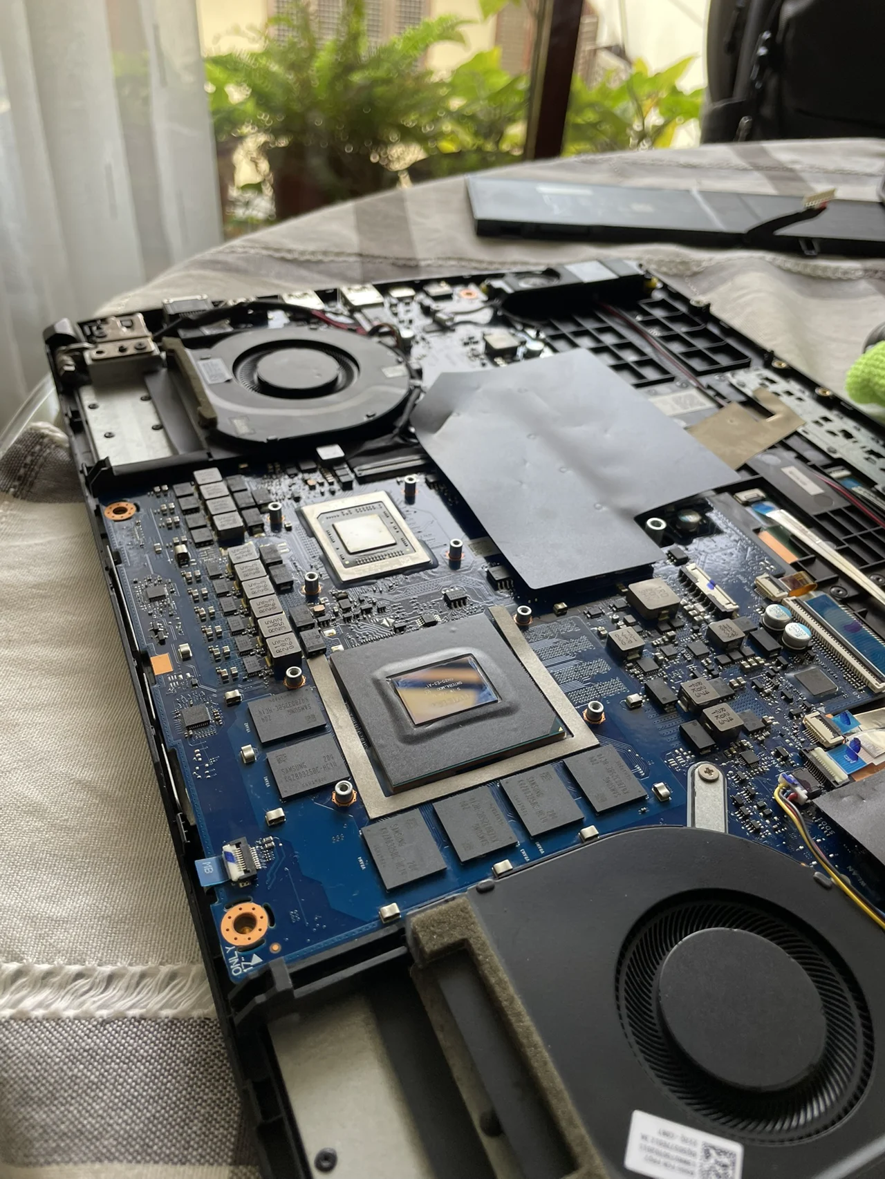 Fotografía real del interior de una laptop abierta, con su placa y sistema de ventilación